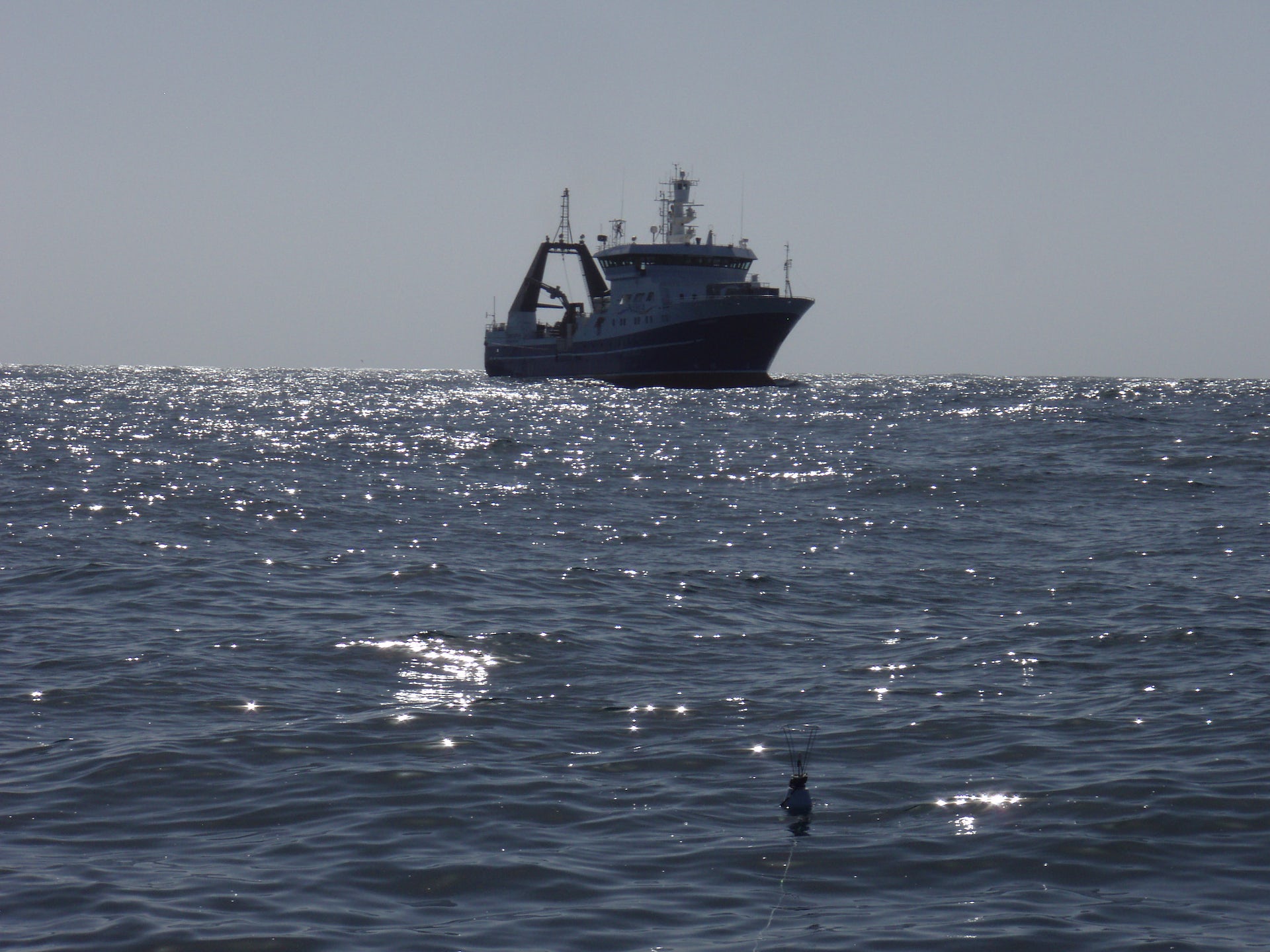 A ship deploys instruments to measure temperature just below the ocean surface.